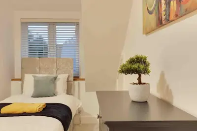 a bedroom with a bed and a potted plant at Foxglove House & Hot Tub Stansted Airport in London Stansted Airport