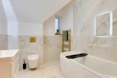 a white bathroom with a tub and a sink at Foxglove House & Hot Tub Stansted Airport in London Stansted Airport