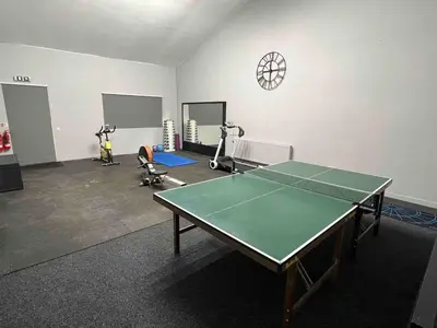 a room with a ping pong table and exercise bikes at An Escape to the Country in Rochford