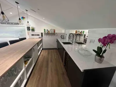 a large white kitchen with a counter and purple flowers at An Escape to the Country in Rochford
