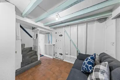 a living room with a couch and a staircase at Charming 3 Bedroom Detached Cottage With Garage in Wormley