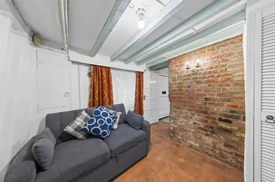 a living room with a couch and a brick wall at Charming 3 Bedroom Detached Cottage With Garage in Wormley