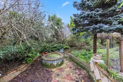 a garden with a tree and a fence at Charming 3 Bedroom Detached Cottage With Garage in Wormley