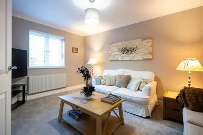 a living room with a white couch and a table at Holly Close in Ipswich