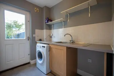 a kitchen with a sink and a washing machine at Holly Close in Ipswich