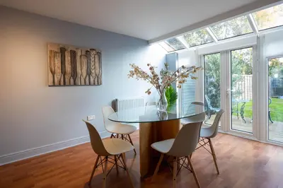 a dining room with a glass table and chairs at Holly Close in Ipswich