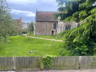 an old stone church with a fence in front of it at Priory View in Saint Osyth