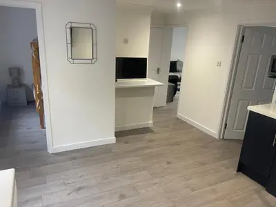 a living room with white walls and wooden floors at Priory View in Saint Osyth
