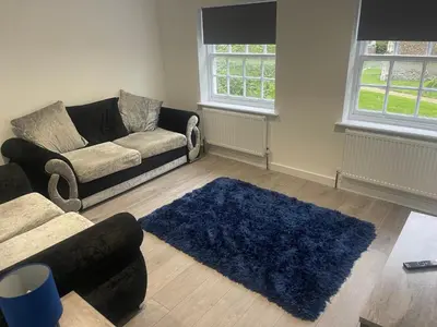 a living room with a couch and a blue rug at Priory View in Saint Osyth