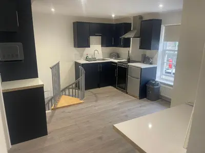 a kitchen with black and white cabinets and a sink at Priory View in Saint Osyth