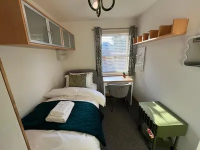a small bedroom with two beds and a desk at 2 Bedroom Apartment 11 Minutes From Stansted Airport in Great Dunmow