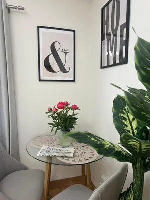 a table with a vase of flowers and two plants at 2 Bedroom Apartment 11 Minutes From Stansted Airport in Great Dunmow