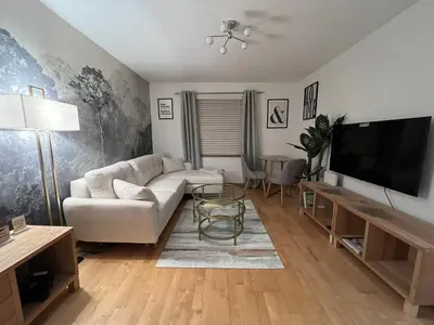 a living room with a white couch and a flat screen tv at 2 Bedroom Apartment 11 Minutes From Stansted Airport in Great Dunmow