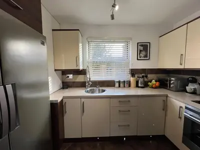 a small kitchen with white cabinets and a sink at 2 Bedroom Apartment 11 Minutes From Stansted Airport in Great Dunmow