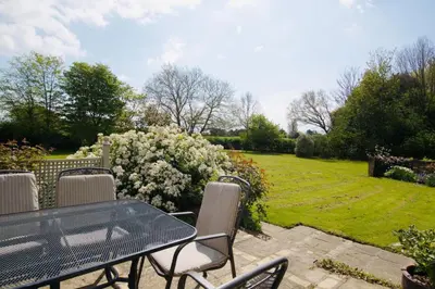 a patio with a table and chairs and a garden at Beautiful country home and garden in Kirby Cross