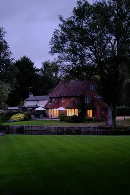 a house with its lights on in the yard at Idle Waters in Dedham