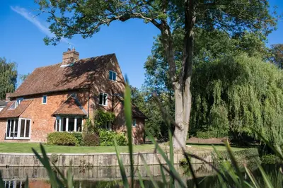 an old brick house with a tree in front of it at Idle Waters in Dedham