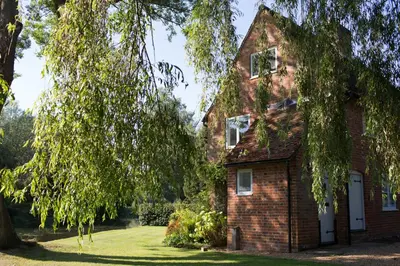 an old brick house with a tree at Idle Waters in Dedham