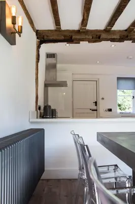a kitchen with white walls and a table and chairs at Idle Waters in Dedham