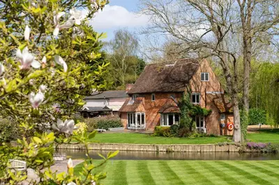 a large brick house with a grass yard at Idle Waters in Dedham