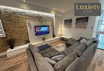 a living room with a couch and a flat screen tv at Sleek & Stunning 2BR APT By Luxiety Stays Short Lets & Serviced Accommodation Southend on sea With Free WiFi, Smart TV, Netflix in Southend-on-Sea