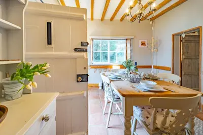 a kitchen with a wooden table and chairs at Swift Host - 2 Bedrooms - Period Cottage - Garden - Village Location - Dog Friendly in Hockham