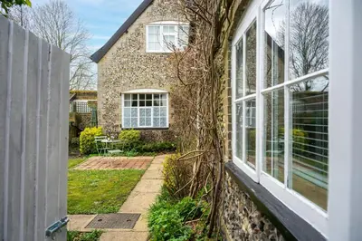 a window of a brick house with vines at Swift Host - 2 Bedrooms - Period Cottage - Garden - Village Location - Dog Friendly in Hockham
