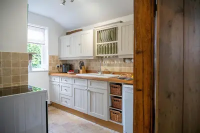 a kitchen with white cabinets and a sink at Swift Host - 2 Bedrooms - Period Cottage - Garden - Village Location - Dog Friendly in Hockham