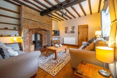 a living room with a couch and a fireplace at Swift Host - 2 Bedrooms - Period Cottage - Garden - Village Location - Dog Friendly in Hockham