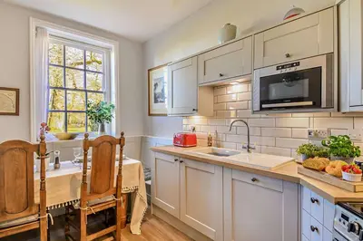 a kitchen with white cabinets and a sink and a microwave at 3 Bed in Wymondham oc-t30596 in Wymondham