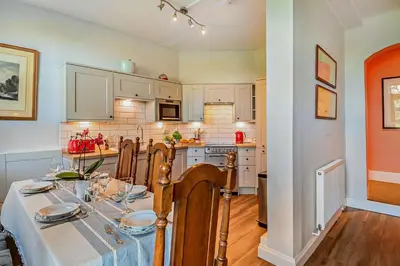 a kitchen with a table and chairs and a kitchen with white cabinets at 3 Bed in Wymondham oc-t30596 in Wymondham