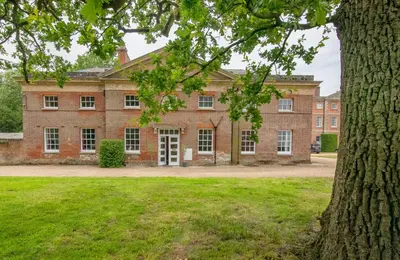 an old brick building with a tree in the foreground at 3 Bed in Wymondham oc-t30596 in Wymondham