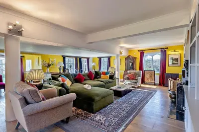 a large living room with a green couch and chairs at 6 Bed in Wymondham oc-t30598 in Wymondham