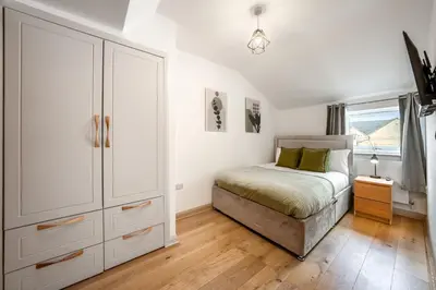 a bedroom with a bed and a dresser and a window at Newmarket House 5 Bedroom 5 En-suite Free Parking in Newmarket