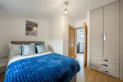 a bedroom with a bed with a blue blanket at Newmarket House 5 Bedroom 5 En-suite Free Parking in Newmarket