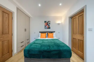 a bedroom with a large green bed with orange pillows at Newmarket House 5 Bedroom 5 En-suite Free Parking in Newmarket