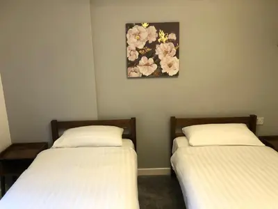 two beds in a room with a picture on the wall at Abbeyfield Guesthouse in Cambridge
