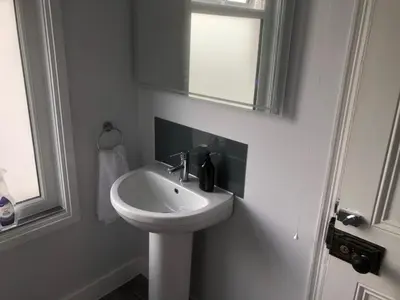 a white bathroom with a sink and a mirror at Abbeyfield Guesthouse in Cambridge