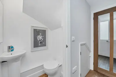 a white bathroom with a toilet and a sink at 7D Albert St - sleeps 4 guests with parking on request in Bury Saint Edmunds