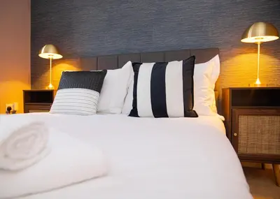 a bedroom with a white bed with black and white pillows at 3x Bed Elegant House with Private Parking in Sawston