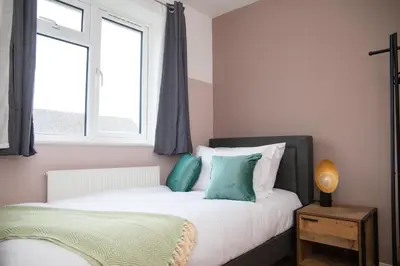a bedroom with a bed and a window at 3x Bed Elegant House with Private Parking in Sawston