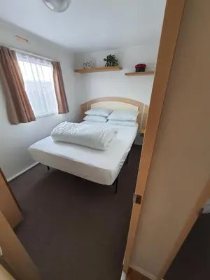 a bedroom with two beds and a window at Buxton's Holiday Home - Park Holiday's complex - Beach Access - Free WiFi in Saint Osyth