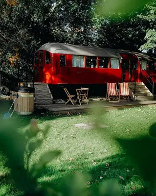 a red train car with two tables and two chairs at Mind The Gap in Preston