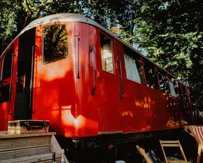 a red train car sitting on the tracks at Mind The Gap in Preston