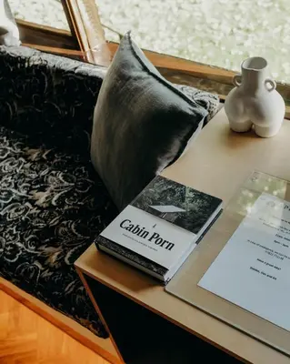 a book on a table next to a couch with a pillow at Mind The Gap in Preston