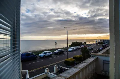 a view of a street with cars parked next to the ocean at Seaview Apartments - 28-29 Marine Parade, Harwich - Perfect for business & long term stays in Dovercourt
