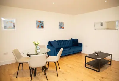 a living room with a blue couch and a table at Seaview Apartments - 28-29 Marine Parade, Harwich - Perfect for business & long term stays in Dovercourt