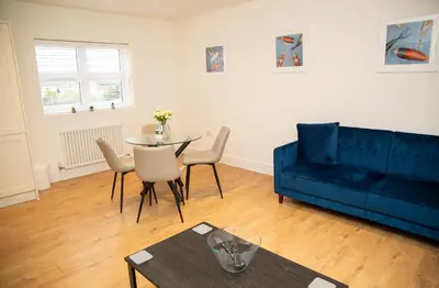 a living room with a blue couch and a table at Seaview Apartments - 28-29 Marine Parade, Harwich - Perfect for business & long term stays in Dovercourt