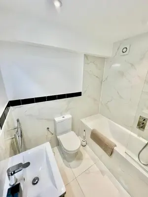 a white bathroom with a toilet and a sink at beautiful 3 bedroom apartment in cambridge sleeps 7 in Milton