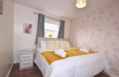 a bedroom with a bed with two towels on it at Highwoods Haven Luxury Stay with Garden and Parking in Mile End